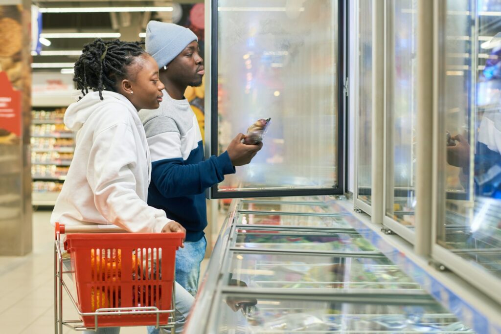 Couple shopping in frozen section at grocery store